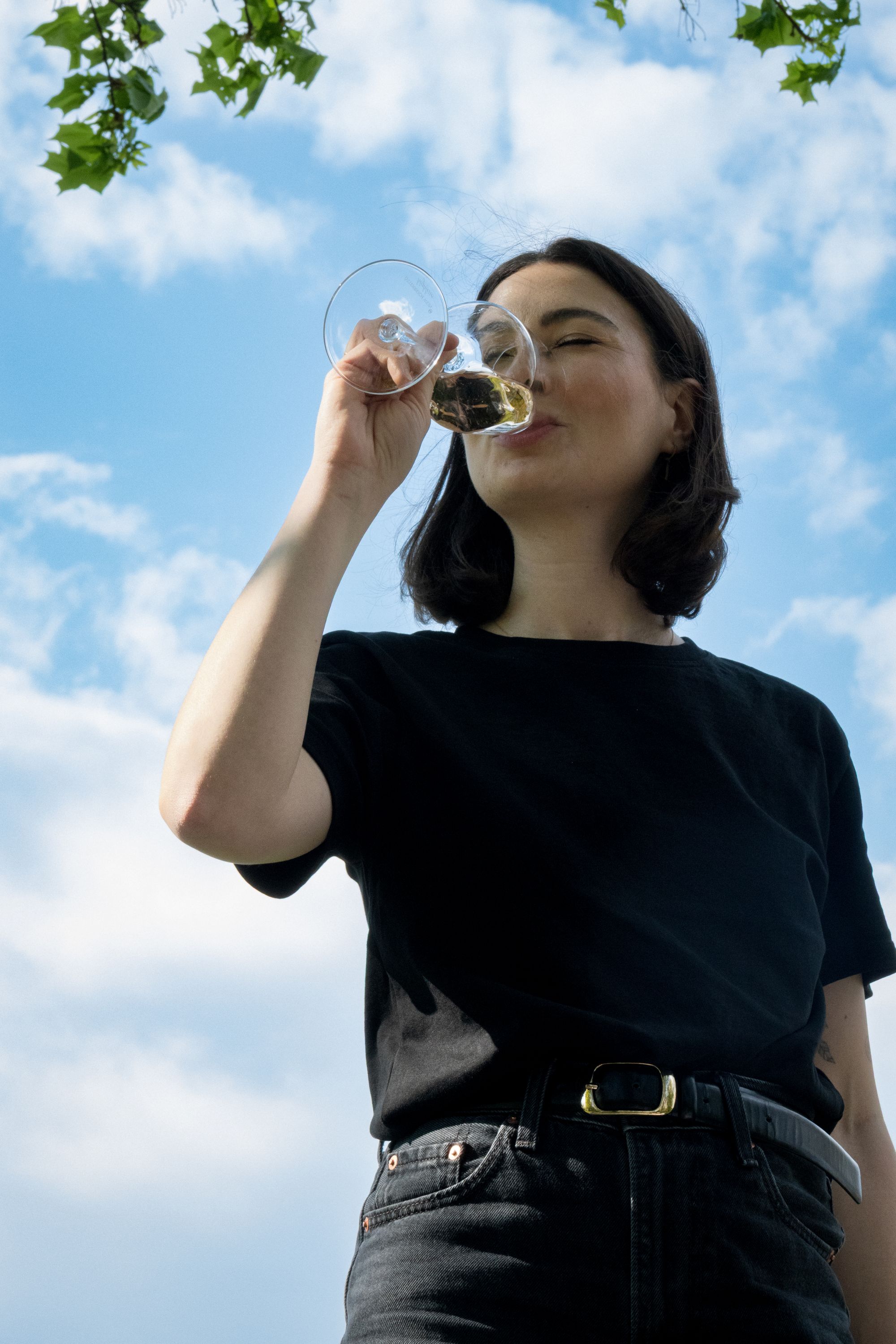 Eine junge Frau trinkt Weißwein aus Österreich im Sommer.