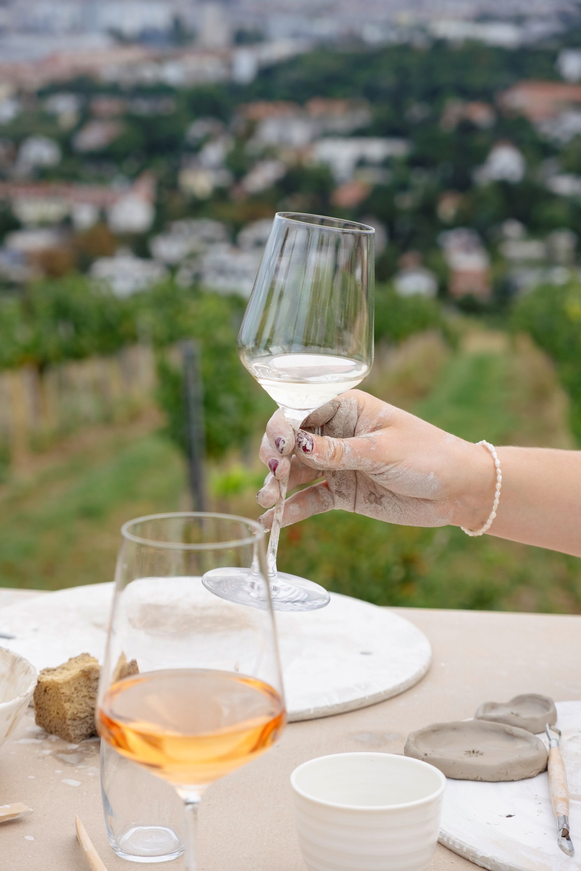 Ein Bild zeigt Menschen beim Töpfern und Wein Trinken.