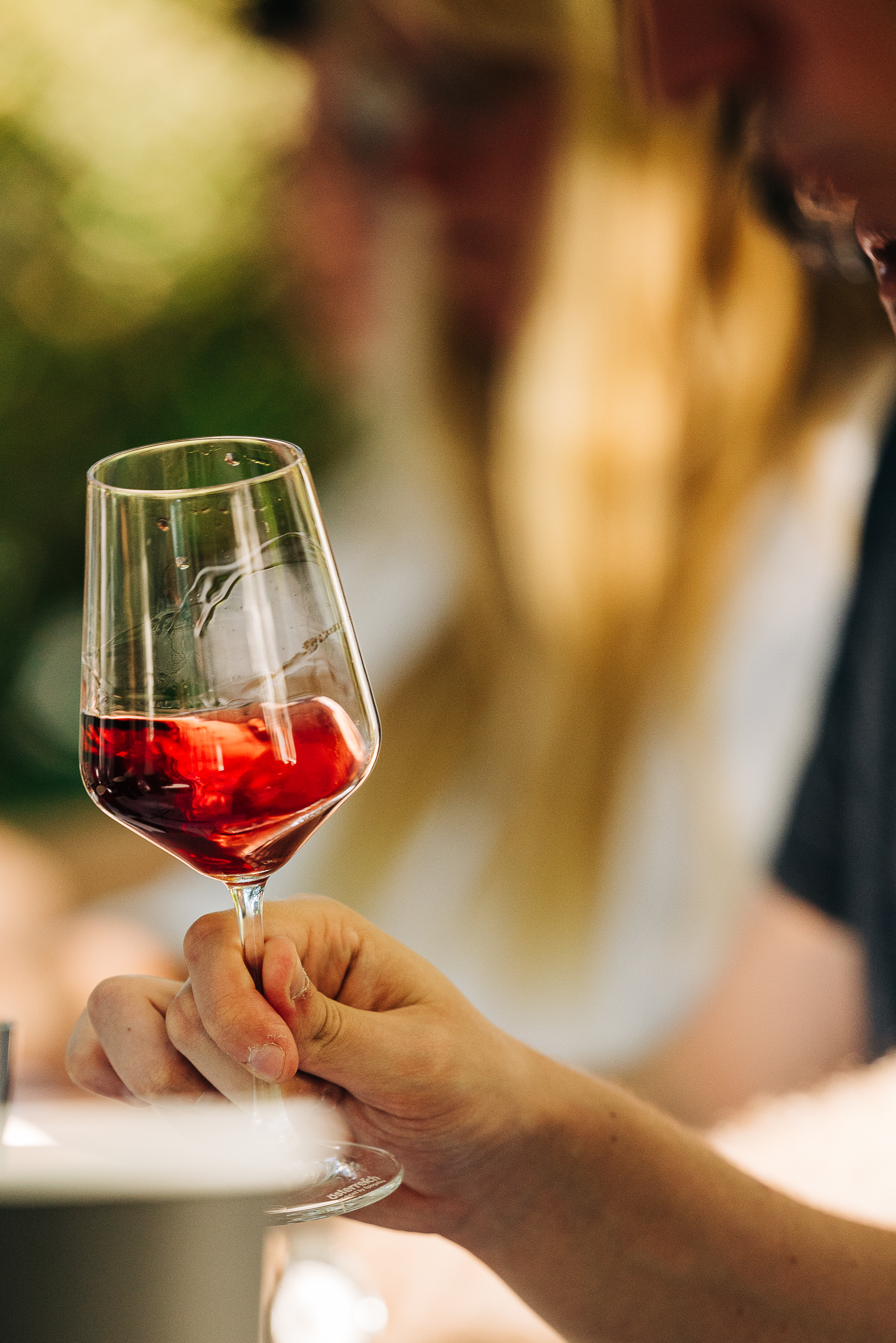 Eine Person schwenkt Rotwein im Glas.