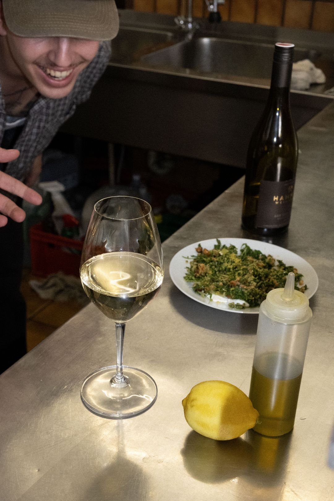 Das Bild zeigt einen jungen Koch mit einem Glas Wein.