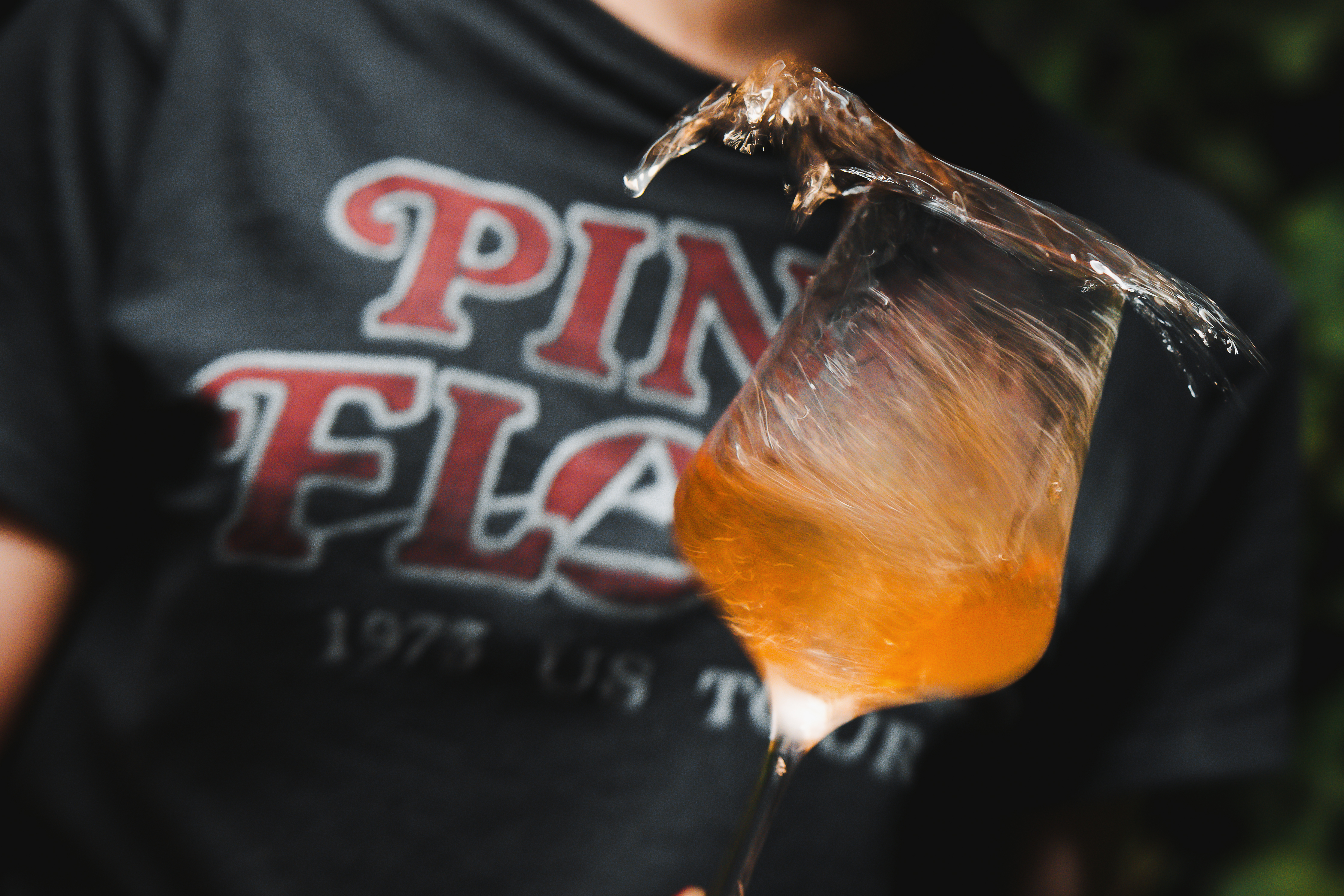 Eine Person verschüttet ein Glas Orange Wine.