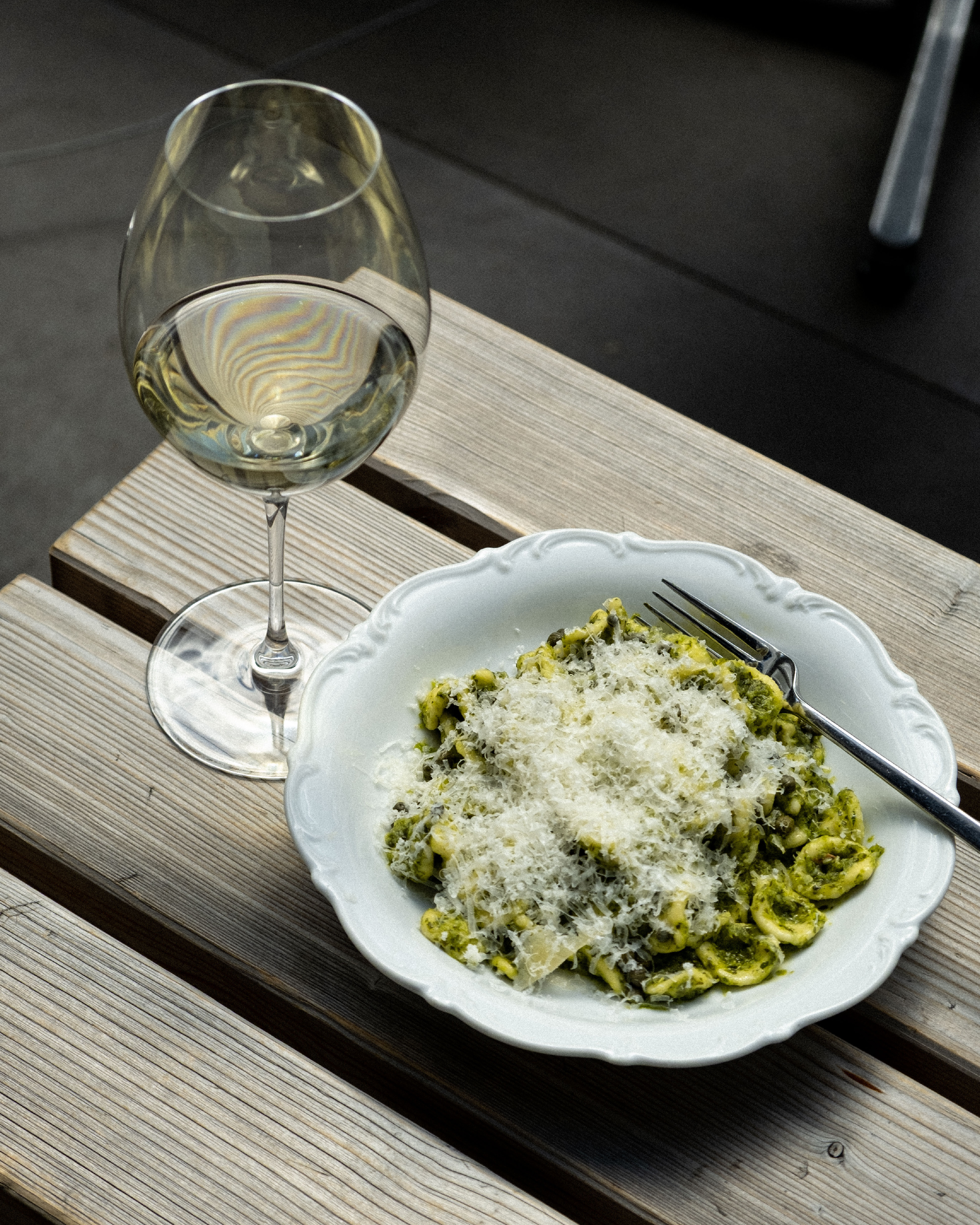 Ein Teller Pasta mit Löwenzahnpesto und ein Glas Sauvignon Blanc
