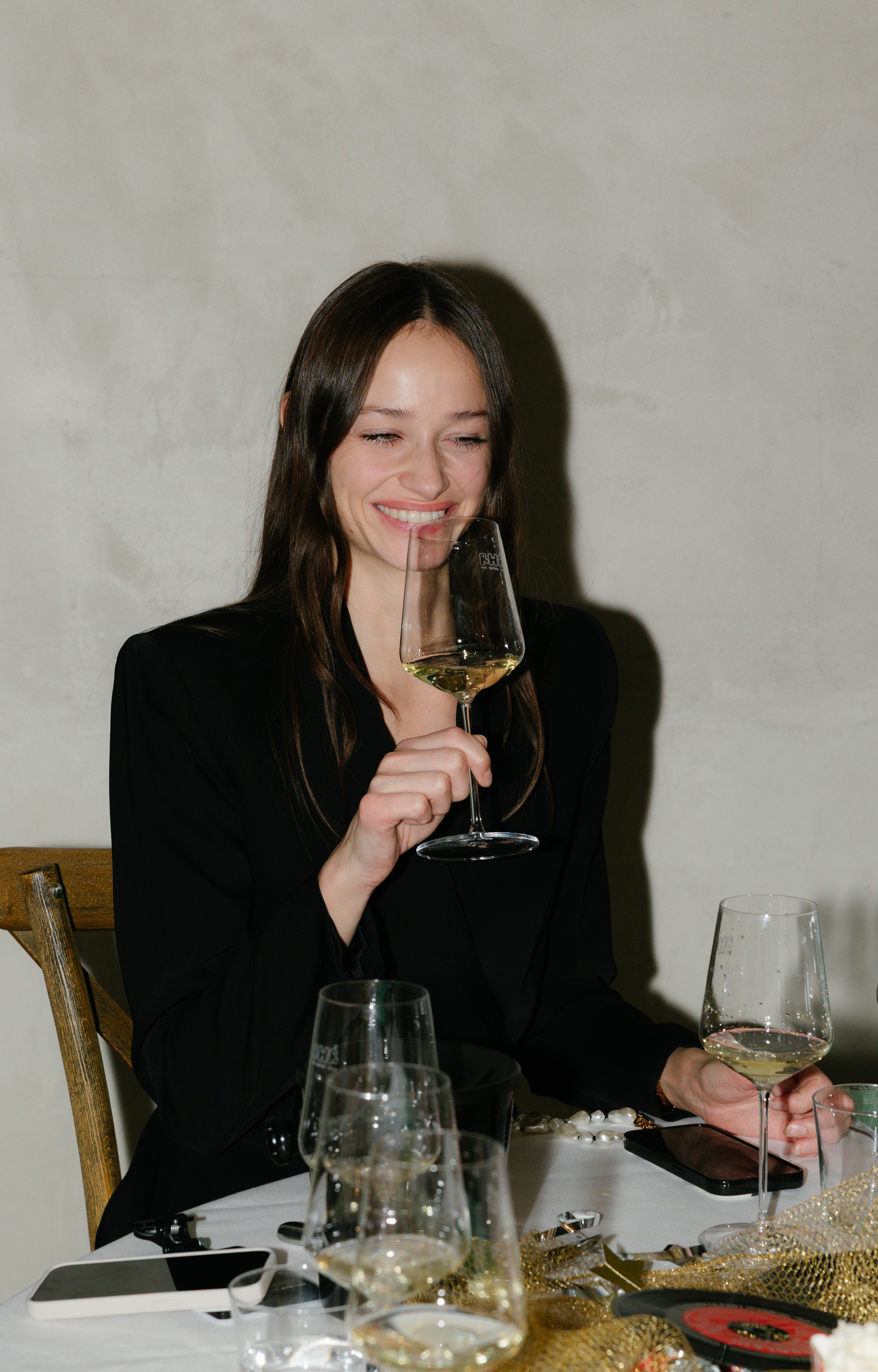 Eine junge Frau trinkt Weißwein und hat Spaß.